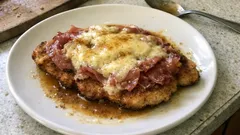 Cotoletta alla bolognese: croccante fuori, con prosciutto e Parmigiano che fondono in padella